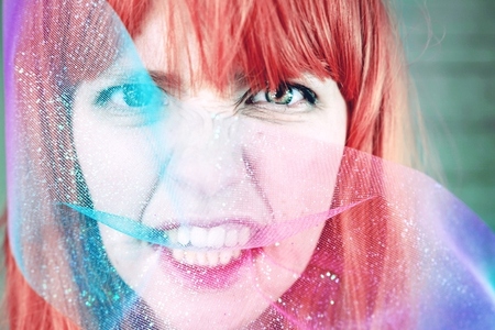 Artistic portrait of a young redhead woman covering by a glitter