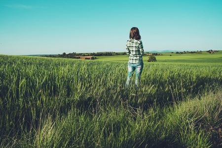 Young woman alone in a green field