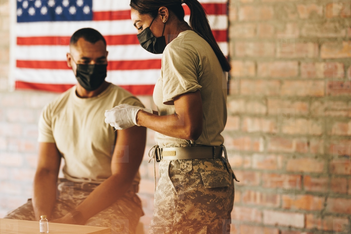 Doctor preparing to administer the covid 19 vaccine to a soldier
