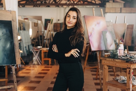Confident painter standing in her workshop