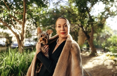High class woman holding her puppy outdoors