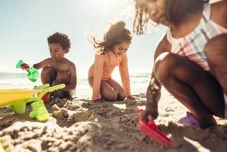 Young friends playing with their toys at the beach