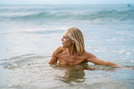 Mature woman in good shape bathing in the sea