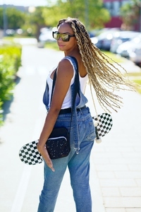 Black girl moving her coloured braids in the wind  Typical African hairstyle