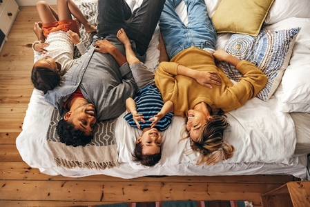 Overhead view of a happy family lying on the bed at home
