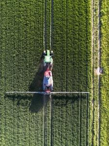 Tractor spraying lush green field Germany