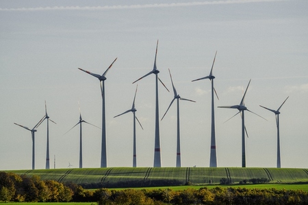 Towering wind turbines in sunny rural countryside field Germany