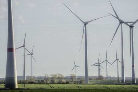 Wind turbine farm in sunny idyllic rural field Germany