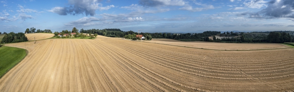 Idyllic panorama of harvested golden hay field on farm