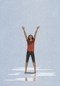 Barefoot exhilarated woman with arms raised in rain