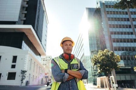 Self confident construction worker standing with his arms crossed