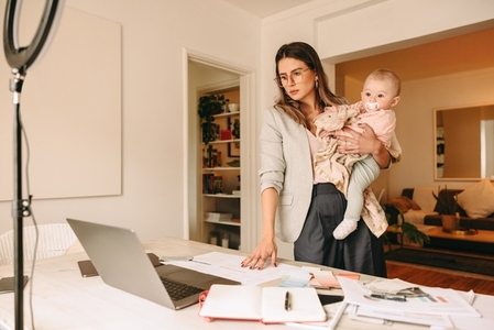 Interior designer holding her baby while working in her home off