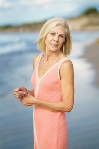 Serene elderly woman on beach in summer