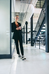 Cheerful businesswoman holding a smartphone in an office