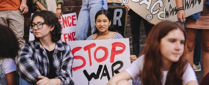 Young woman holding an anti war banner during a protest