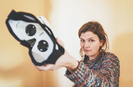 Forced perspective image of a young woman holding the lenses of