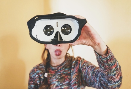 Forced perspective image of a young woman holding the lenses of