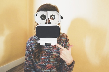 Image of a young woman showing the inside of a cardboard vr glas