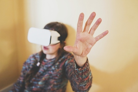 Spontaneous portrait of a young woman using cardboard vr glasses