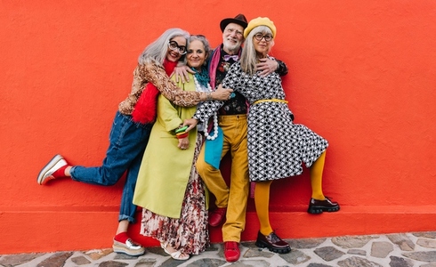 Four happy senior citizens having fun in colourful clothing