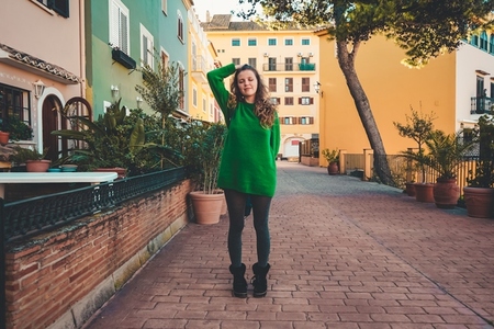 Young woman wearing green oversize sweater enjoying a windy day