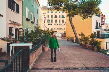 Young woman wearing green oversize sweater enjoying a windy day