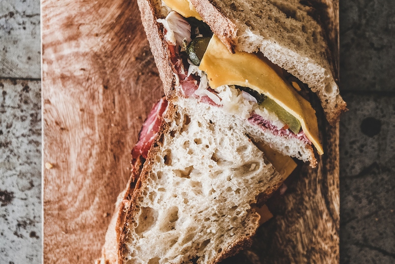 Flat-lay of pastrami sandwich slices in sourdough bread with cheese