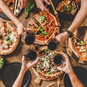 People clinking glasses over table with Italian pizza  square crop