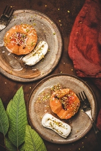 Turkish dessert boiled quince with spices  pistachio  kaymak on plate