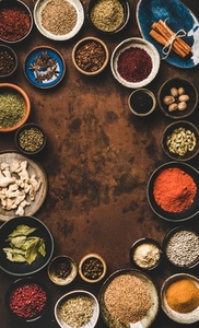 Flat lay of spices in bowls over rusty background  vertical composition