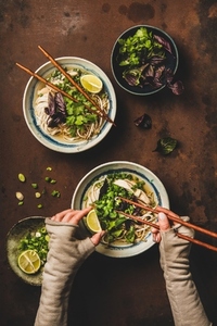 Vietnamese soup Pho Ga and womans hands with chopsticks  flat lay