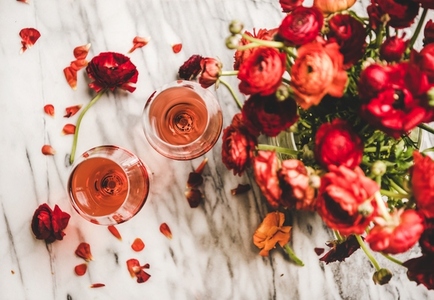 Rose wine in glasses and red spring flowers  top view