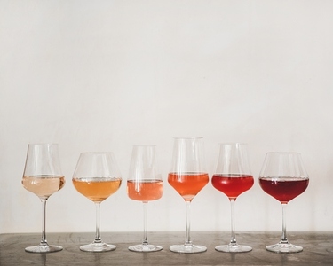 Various shades of Rose wine in glasses on concrete table