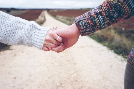 Closeup of a young couple held hands showing their engagement in