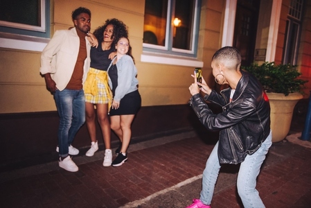 Woman taking a picture of her friends at night