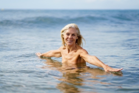 Eldery woman in good shape bathing in the sea