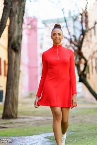 Smiling black woman in red dress walking down the street
