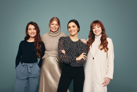 Smiling group of women standing in a studio