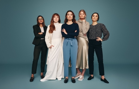 Five empowered women standing together in a studio