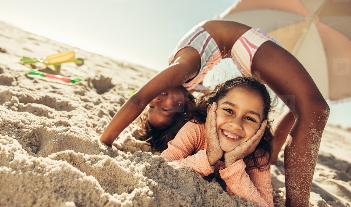 Active little girls having fun together at the beach