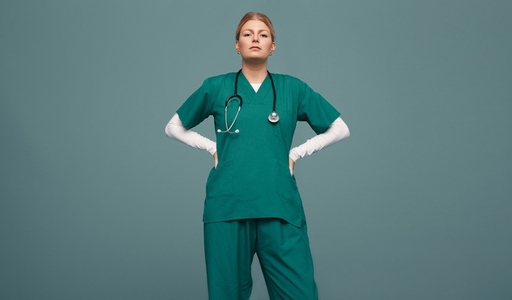 Female doctor wearing green scrubs in a studio