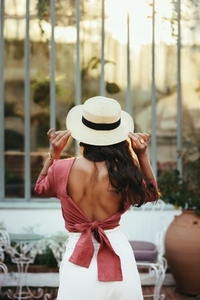 Rearview of a young woman posing in a summer hat