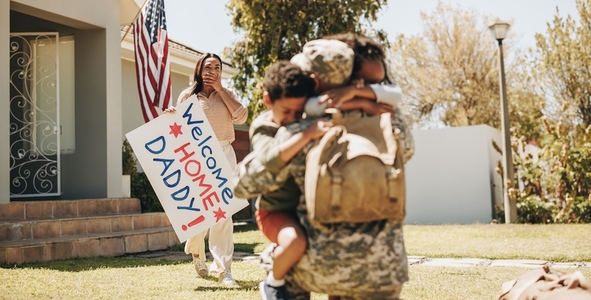 Patriotic soldier being welcomed by his family at home