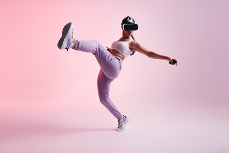 Active young woman throwing a kick in a 3D game