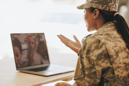Female soldier video calling her family on a laptop