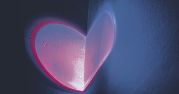 Colorful light heart shape projected in a wall