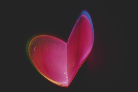 Colorful light heart shape projected in a wall