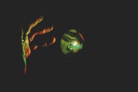 Hand trying to touch a magic colorful ball