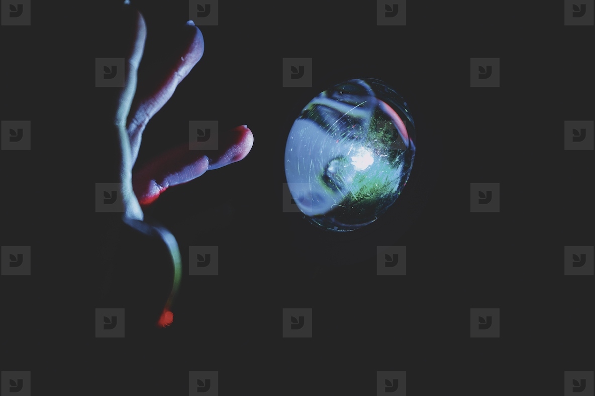Hand trying to touch a magic colorful ball