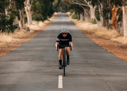 Athlete cycling on empty country road  Professional cyclist training outdoors